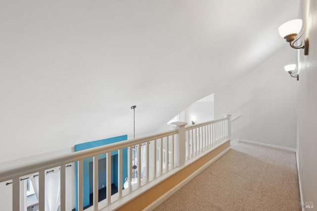 corridor featuring vaulted ceiling and light carpet