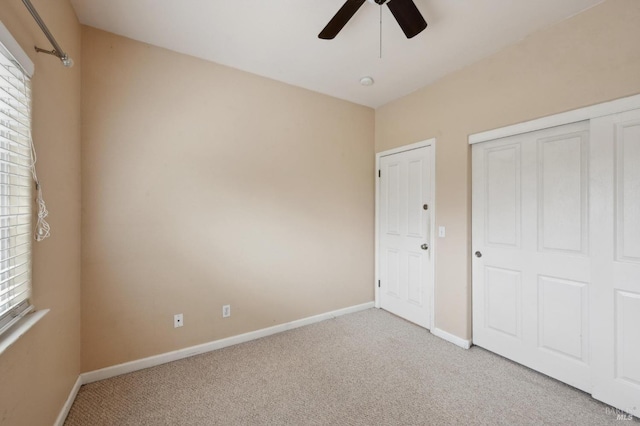 unfurnished bedroom with light carpet, ceiling fan, and a closet