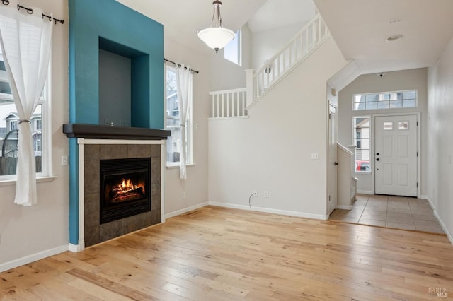 entryway featuring a high ceiling, a wealth of natural light, and light hardwood / wood-style floors