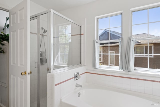 bathroom featuring a healthy amount of sunlight and separate shower and tub