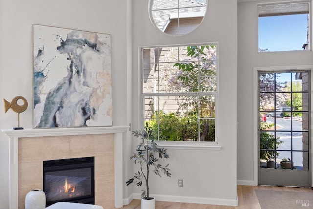 living room featuring a tile fireplace and light wood-type flooring