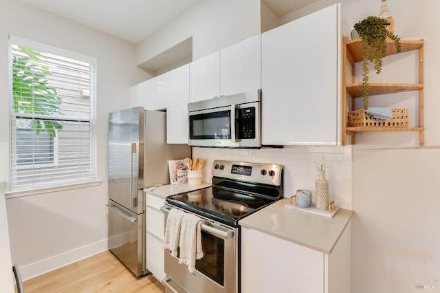 57 Lakeshore Ct, Richmond, CA 94804 - kitchen featuring light wood finished floors, open shelves, decorative backsplash, appliances with stainless steel finishes, and white cabinetry
