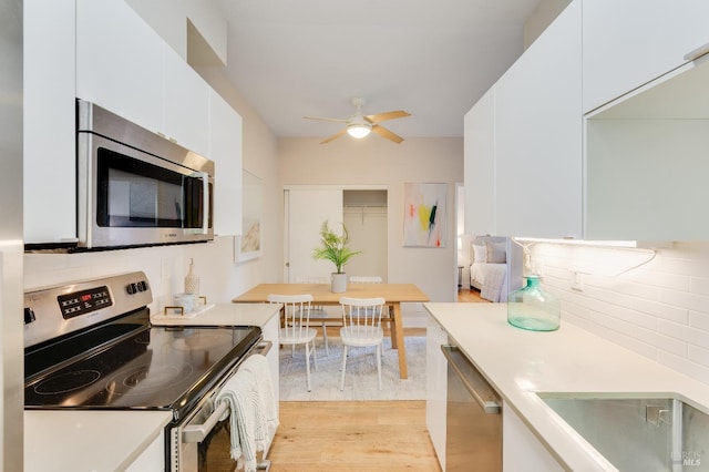 57 Lakeshore Ct, Richmond, CA 94804 - kitchen featuring light wood finished floors, white cabinets, a ceiling fan, light countertops, and appliances with stainless steel finishes