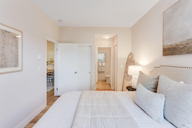 57 Lakeshore Ct, Richmond, CA 94804 - bedroom with baseboards, wood finished floors, and connected bathroom