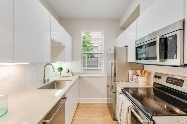 57 Lakeshore Ct, Richmond, CA 94804 - kitchen with a sink, light wood-type flooring, baseboards, appliances with stainless steel finishes, and white cabinetry