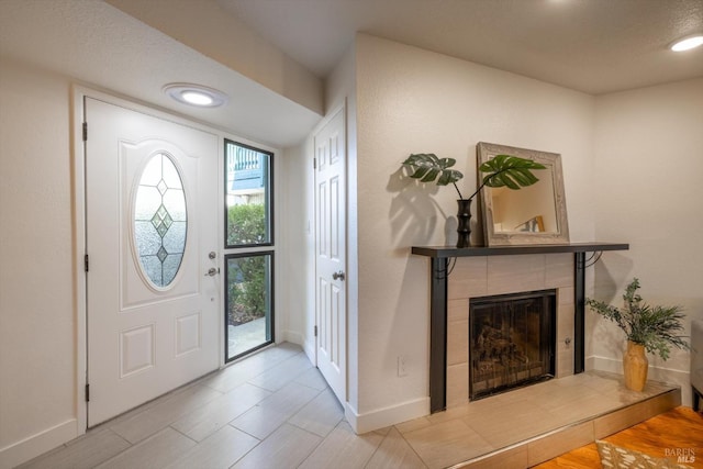 foyer with a tile fireplace