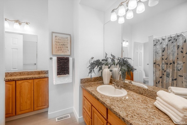 bathroom featuring vanity, toilet, and walk in shower