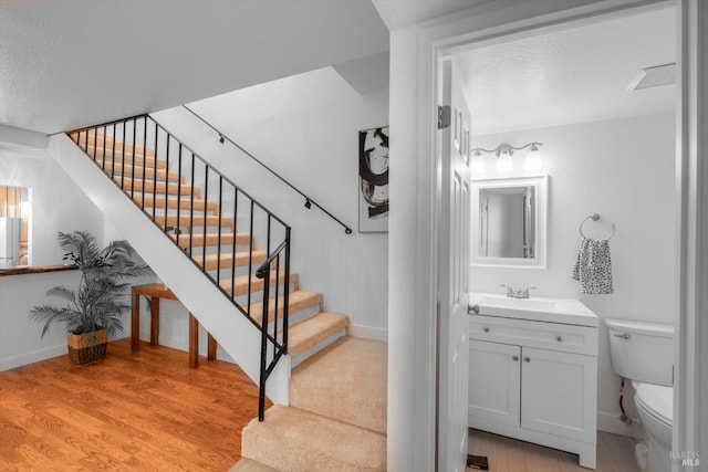 stairway featuring hardwood / wood-style floors and a textured ceiling