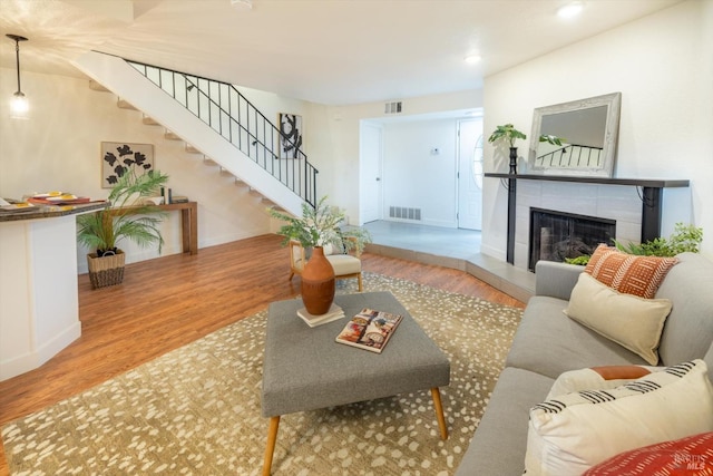 living room with light hardwood / wood-style floors and a tile fireplace