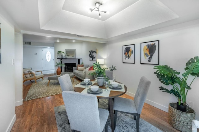 dining room with a raised ceiling and hardwood / wood-style floors