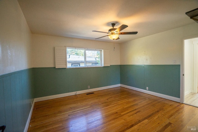 spare room featuring hardwood / wood-style flooring and ceiling fan