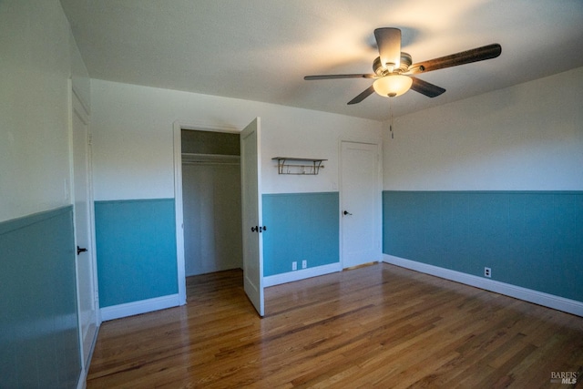 unfurnished bedroom featuring wood-type flooring, ceiling fan, and a closet