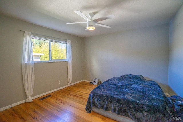 bedroom with wood-type flooring and ceiling fan