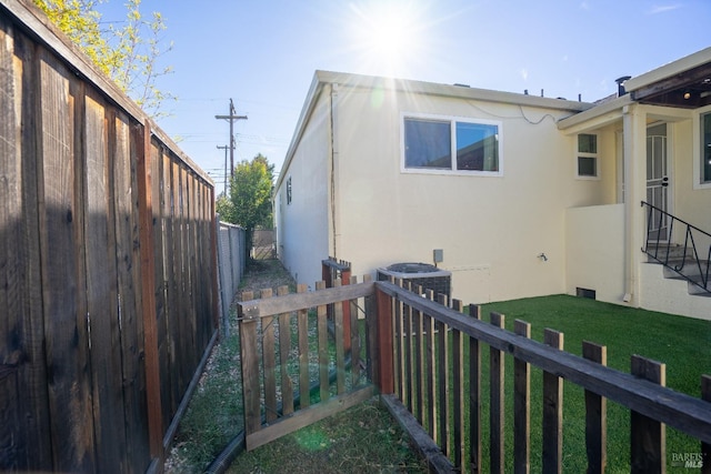 view of property exterior with a yard and central air condition unit