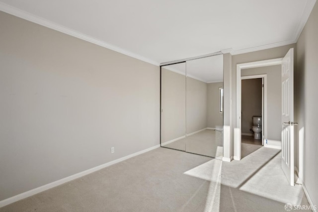 unfurnished bedroom featuring crown molding, light carpet, and a closet