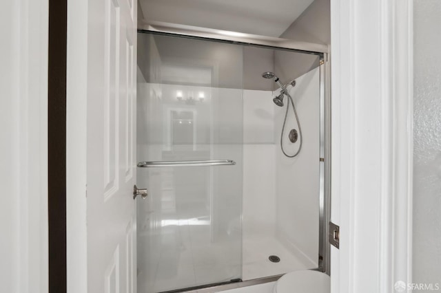 bathroom with a shower with door