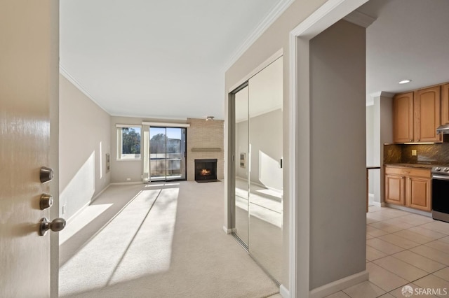 living room with crown molding, a large fireplace, and light tile patterned floors