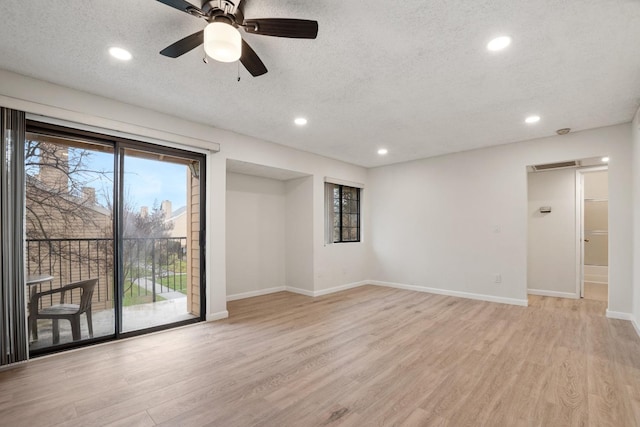 empty room with recessed lighting, light wood-type flooring, baseboards, and a textured ceiling