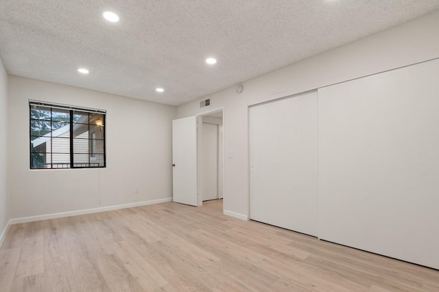 unfurnished bedroom with light wood-style floors, recessed lighting, visible vents, and a textured ceiling