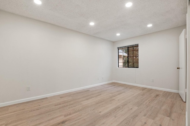 unfurnished room with baseboards, light wood-type flooring, recessed lighting, and a textured ceiling