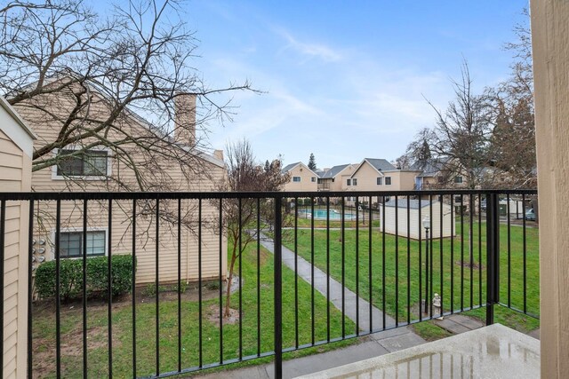 view of gate with a residential view, a community pool, and a lawn