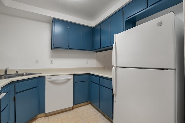 kitchen with light countertops, white appliances, blue cabinetry, and a sink