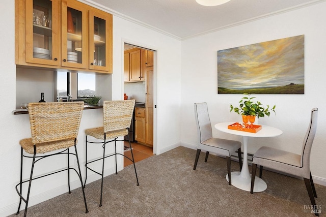 carpeted dining space featuring ornamental molding