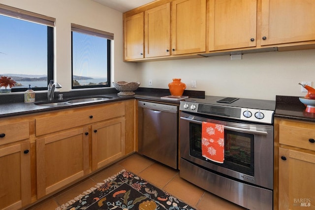 kitchen with appliances with stainless steel finishes, sink, and light tile patterned floors