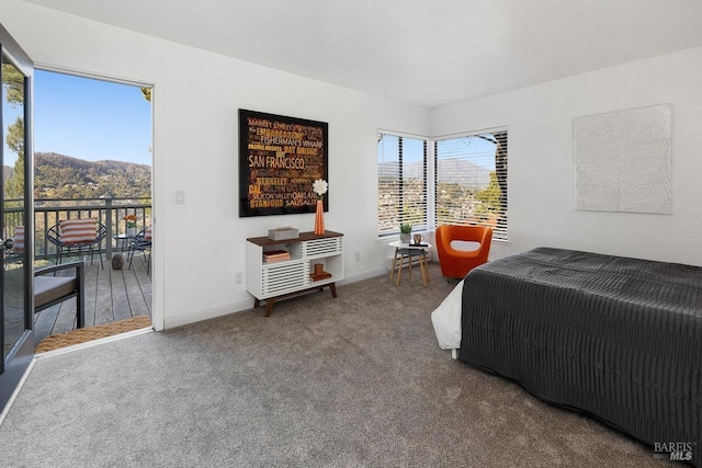 carpeted bedroom featuring multiple windows, a mountain view, and access to outside