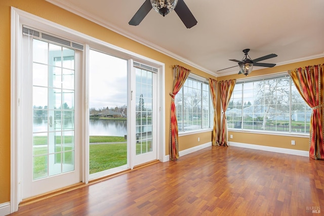 unfurnished sunroom featuring ceiling fan, a healthy amount of sunlight, and a water view