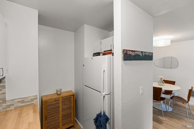 kitchen featuring white refrigerator, light hardwood / wood-style flooring, and white cabinets