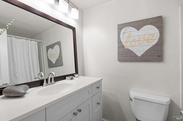 bathroom with vanity, curtained shower, and toilet