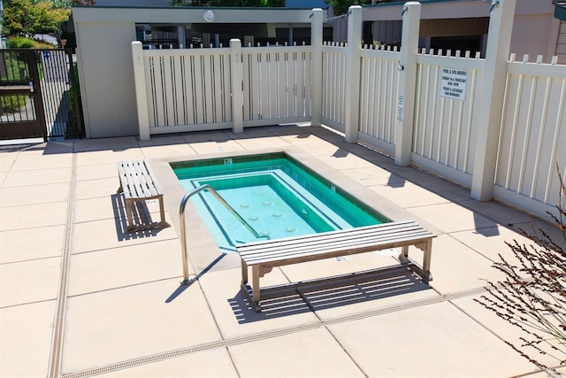 view of swimming pool with a community hot tub and a patio area