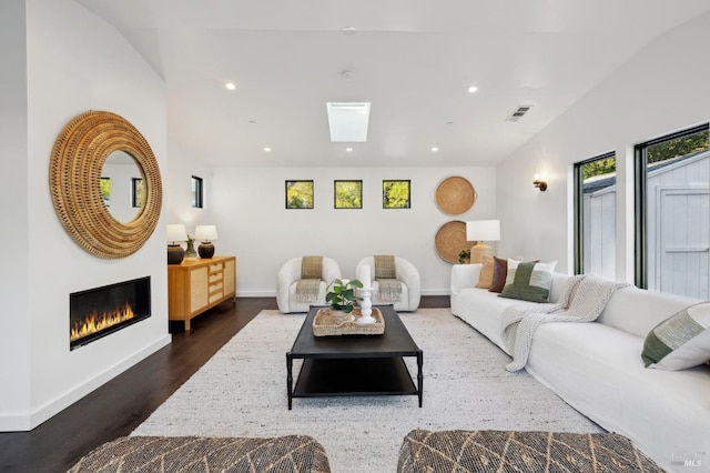 living room featuring dark hardwood / wood-style flooring and a skylight