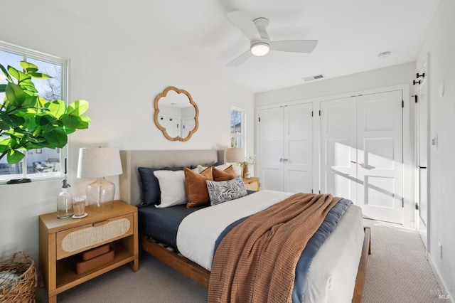 carpeted bedroom featuring two closets and ceiling fan