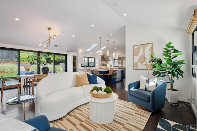 living room featuring lofted ceiling, a chandelier, and light wood-type flooring