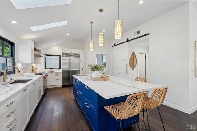 kitchen featuring sink, white cabinetry, a center island, premium appliances, and a barn door