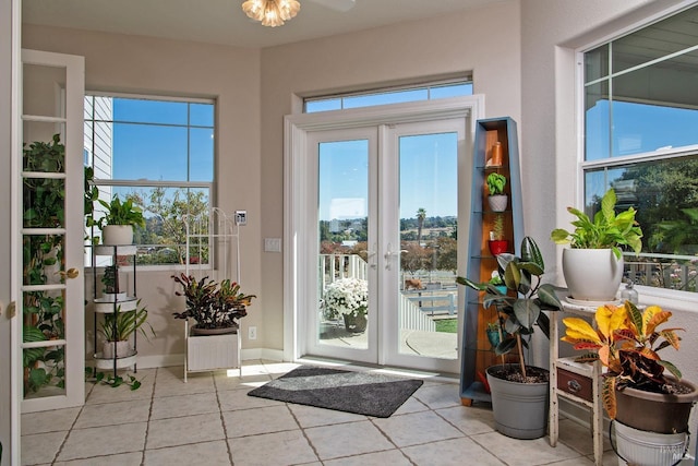 entryway featuring tile patterned flooring, french doors, and baseboards