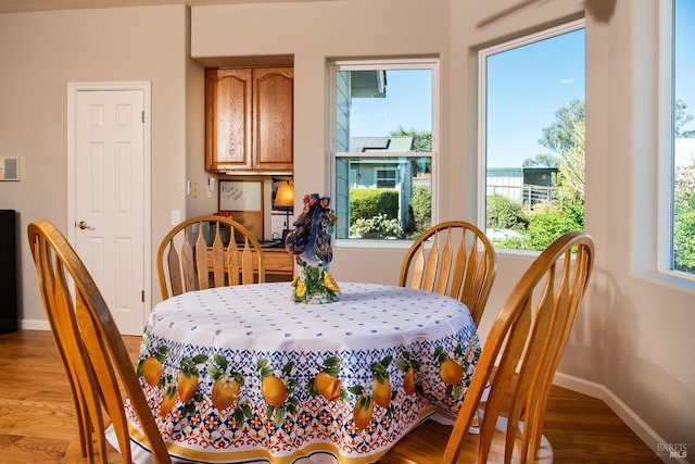 dining space with baseboards and light wood-style floors