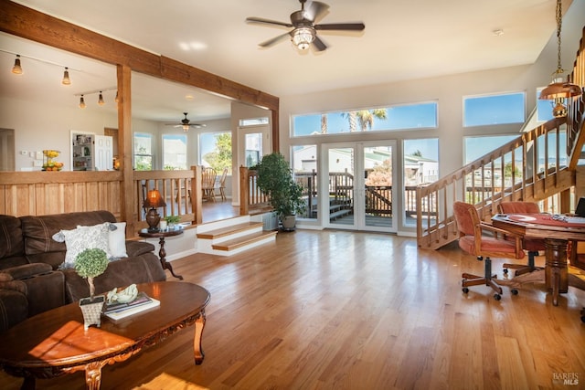 living area featuring stairway, a ceiling fan, and wood finished floors