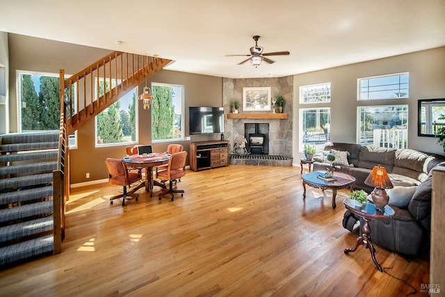 living area featuring stairway, a healthy amount of sunlight, ceiling fan, and wood finished floors