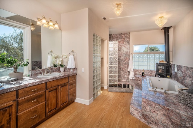 full bathroom featuring visible vents, plenty of natural light, wood finished floors, and vanity