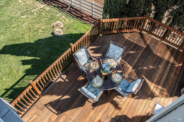 wooden deck with a lawn and outdoor dining area