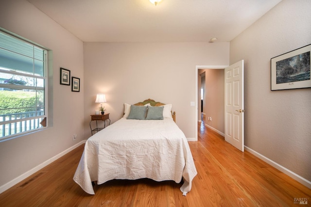 bedroom featuring light wood-style flooring, visible vents, and baseboards