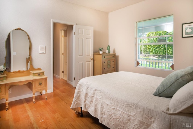 bedroom with baseboards and light wood finished floors