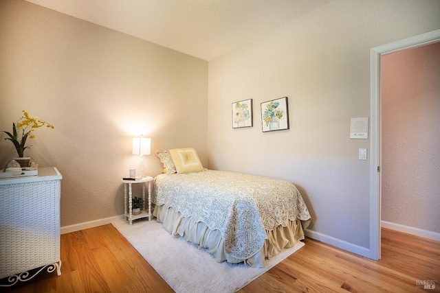 bedroom featuring baseboards and wood finished floors