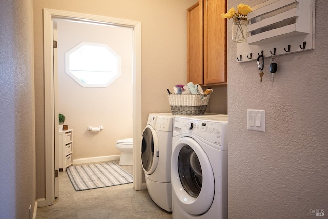 laundry room with cabinet space, baseboards, and washer and clothes dryer