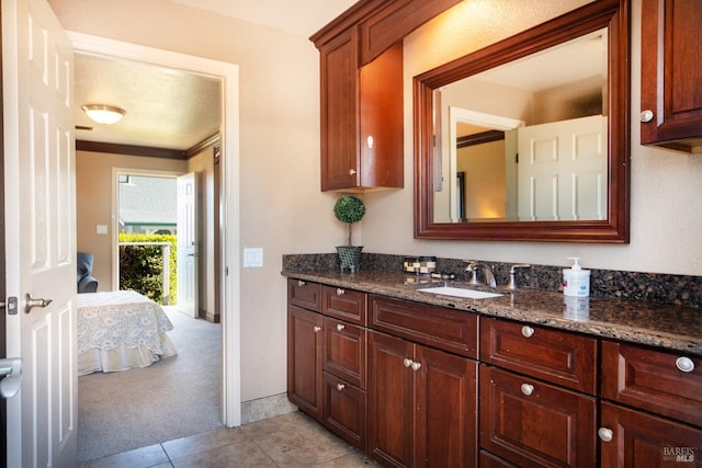 ensuite bathroom with tile patterned flooring, vanity, and ensuite bath