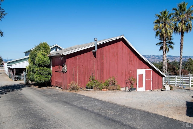 view of outdoor structure featuring a mountain view, an outdoor structure, and fence