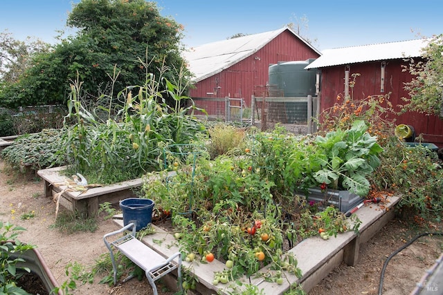 view of yard with an outbuilding, a vegetable garden, and fence